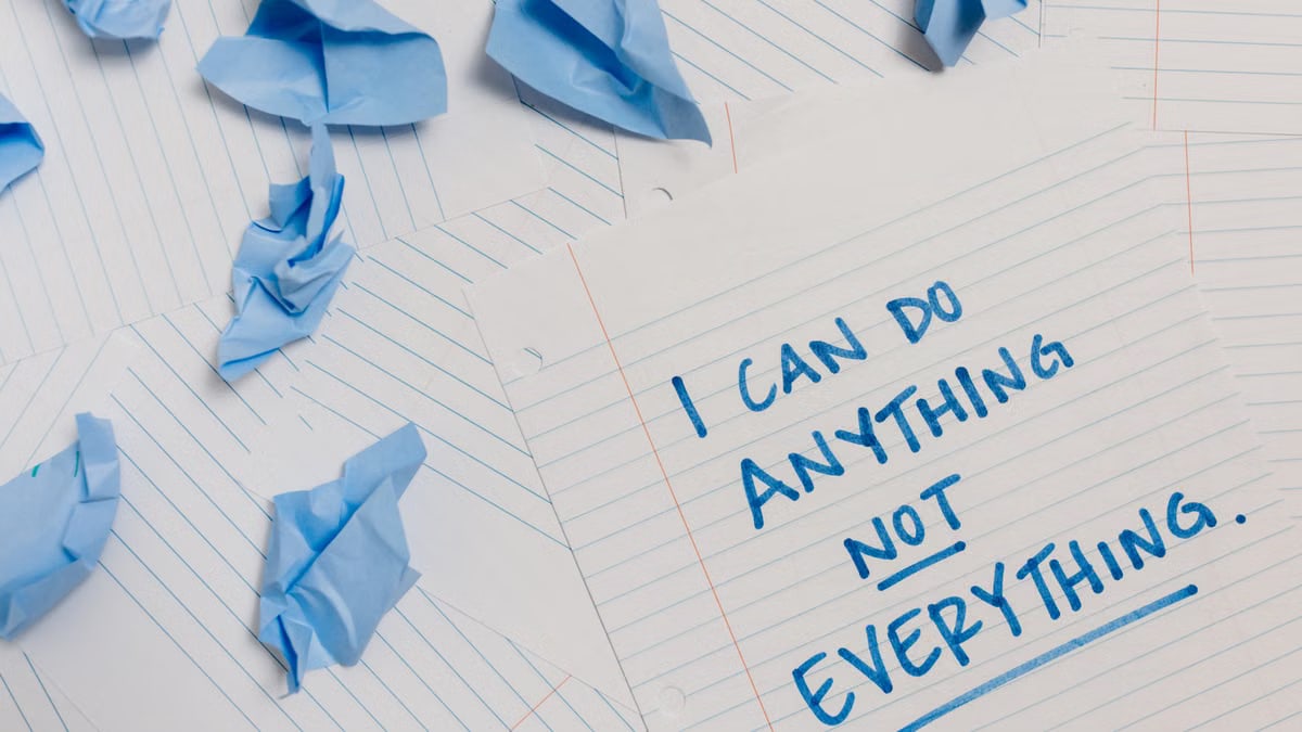 Inspirational quote on paper surrounded by crumpled blue sheets, conveying motivation.